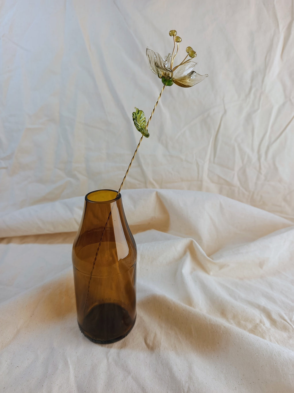 Fleur éternelle en verre recyclé sur tige laiton avec  son soliflore en bouteille de bière surcyclé