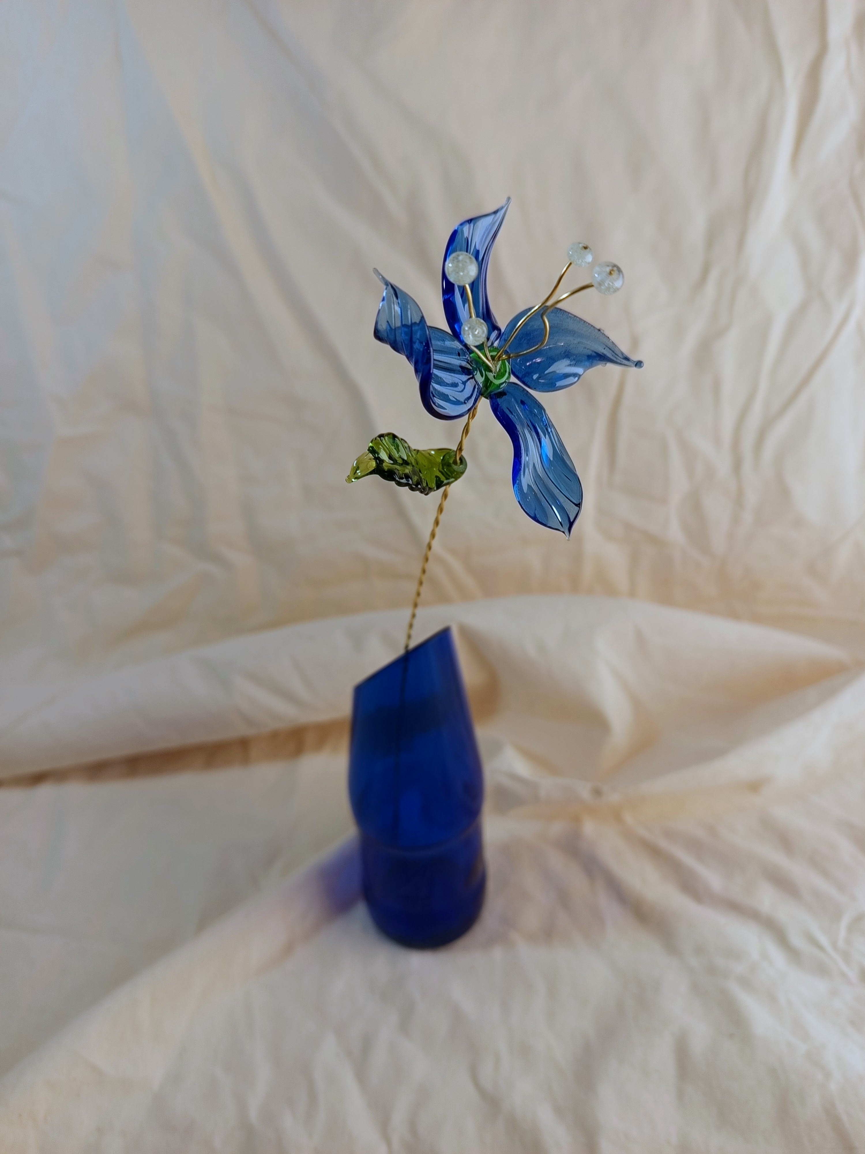 Fleur éternelle en verre recyclé bleue sur tige laiton et son soliflore en bouteille de bière surcyclée